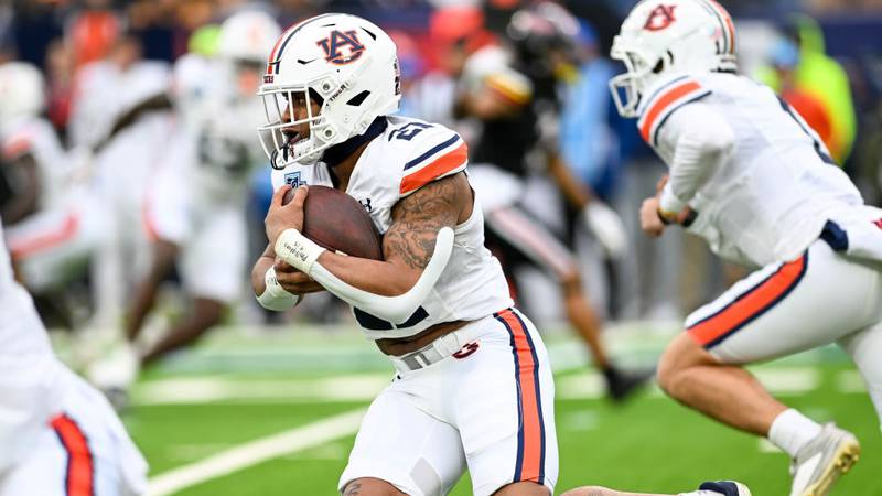 Running back Brian Battie carrying a football during a bowl game.