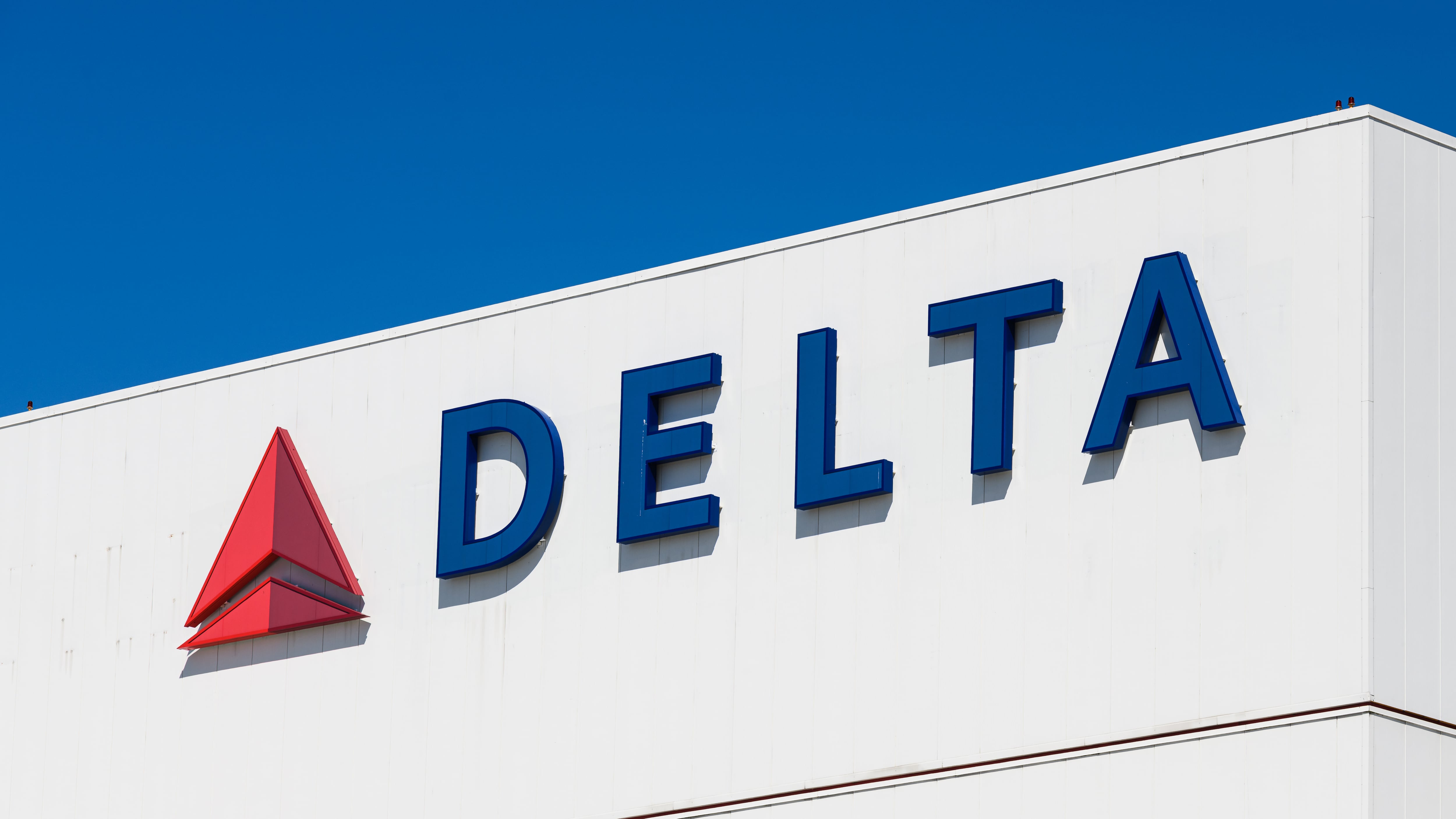 Delta Airlines corporate logo and workmark on a white building.